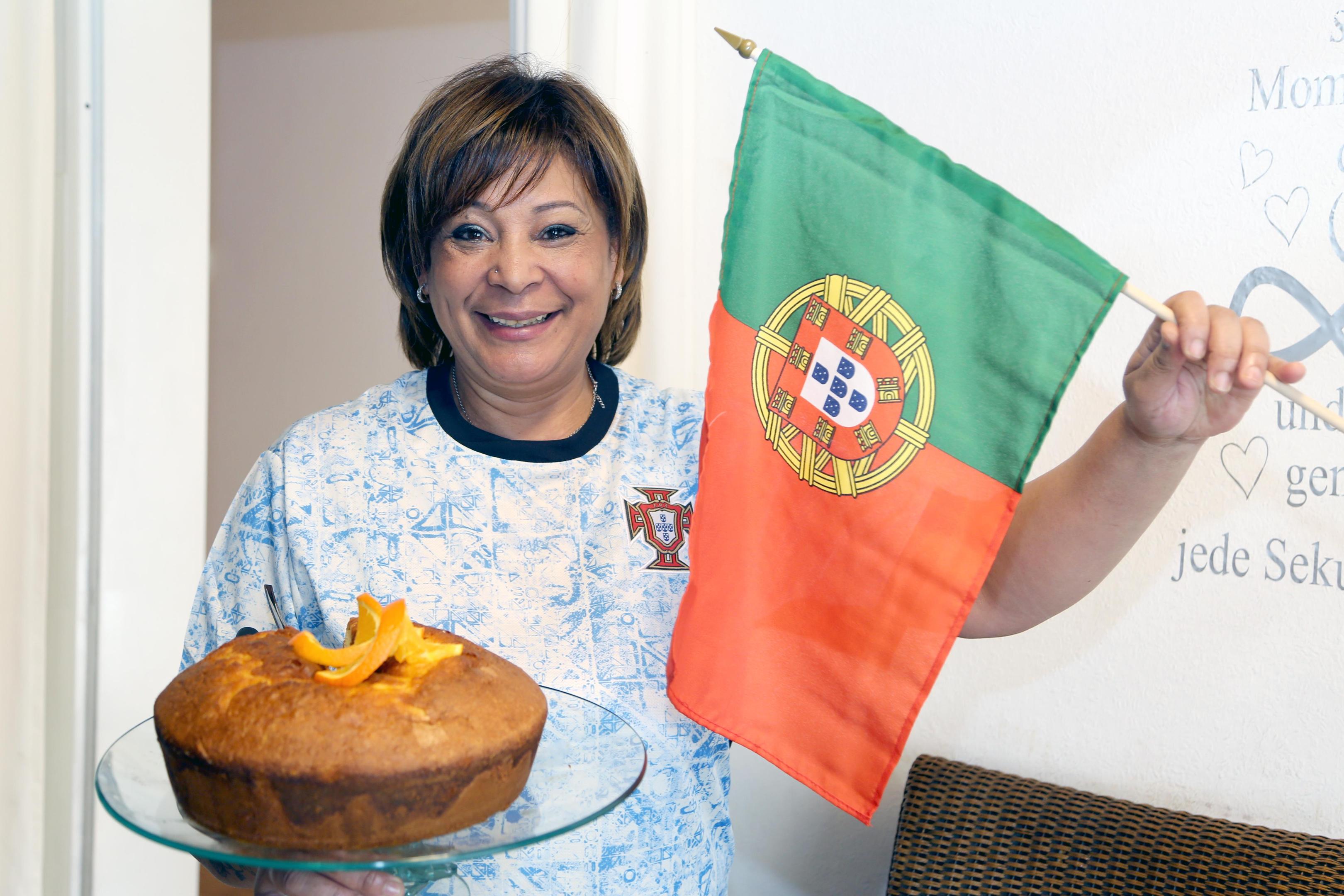 Im neuen Nationaltrikot der portugiesischen Fußballmannschaft, mit Flagge und ihrem frisch gebackenen Orangenkuchen freut sich Augusta Morais schon jetzt riesig auf die zweite Festa Portuguesa am Wochenende nach Ostern auf dem Heinsberger Marktplatz. 