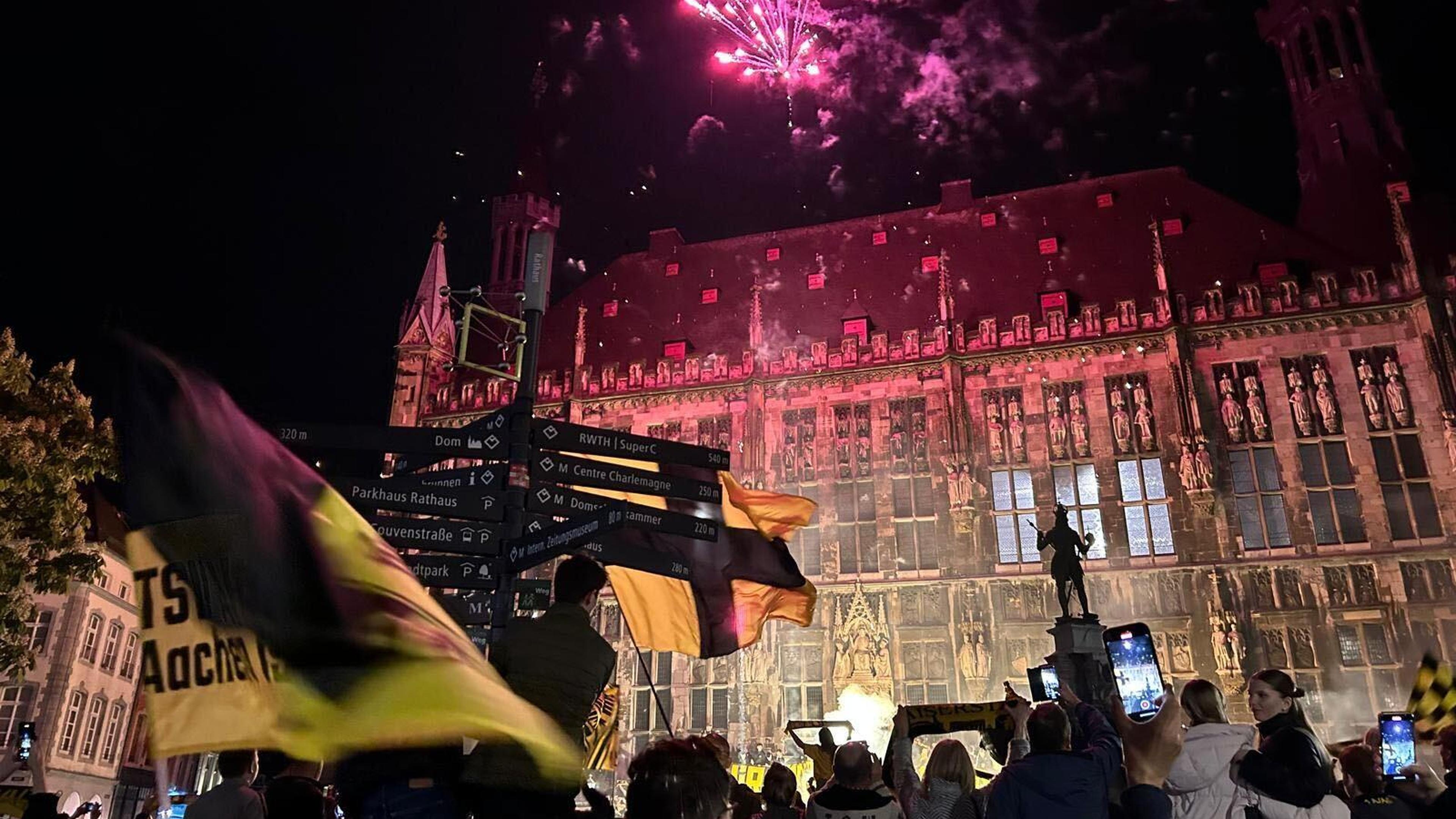 Feuerwerk über und vor dem Aachener Rathaus: Ausgelassen feierten Tausende Alemannia-Fans in der Nacht zum Samstag den Aufstieg in die Dritte Liga.