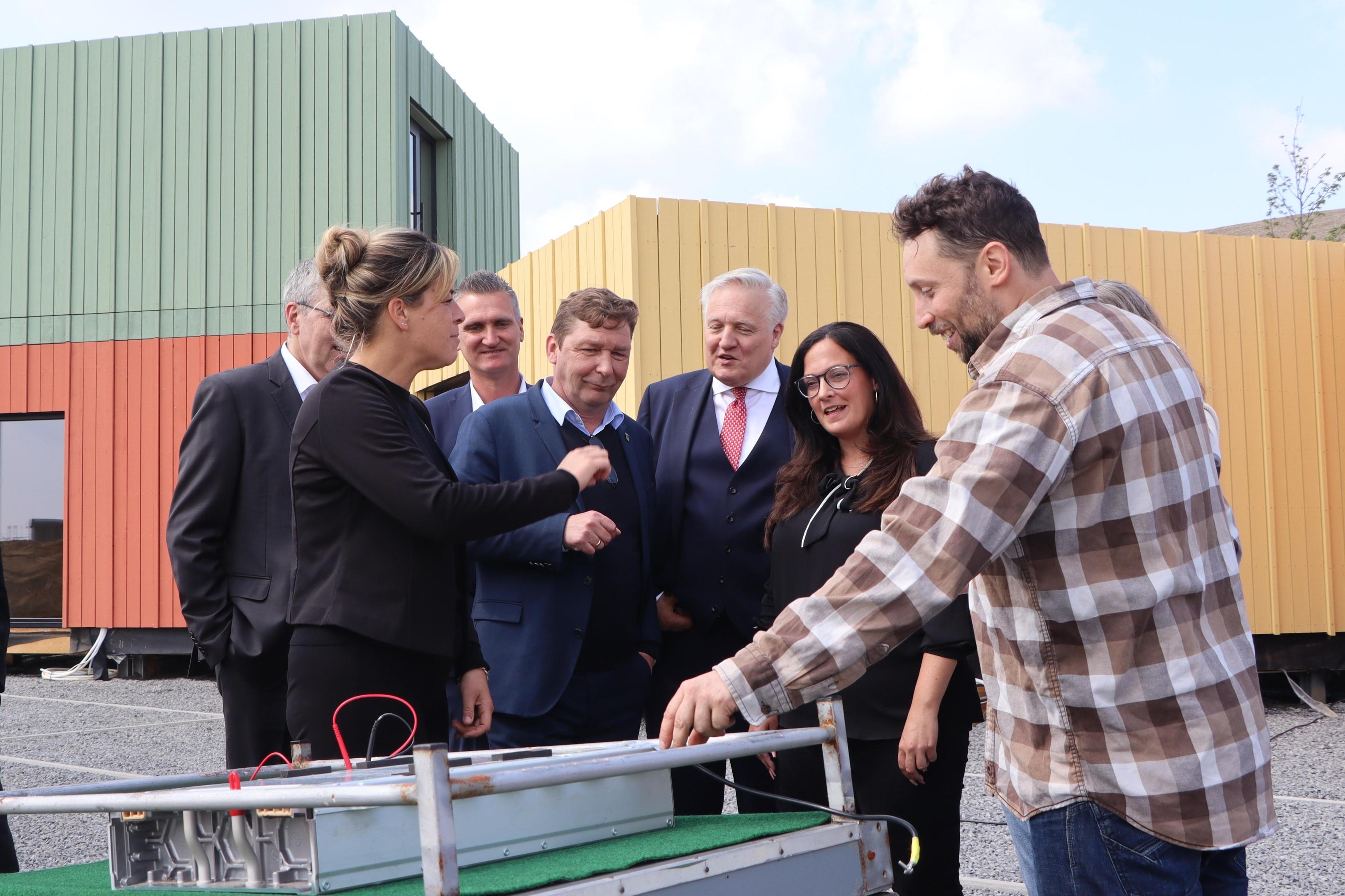 Praktisches Beispiel: Wirtschaftsministerin Mona Neubaur lässt sich erklären, wie ein Jülicher Start-up die Catering-Wagen bei der Eröffnung mit Strom versorgt.