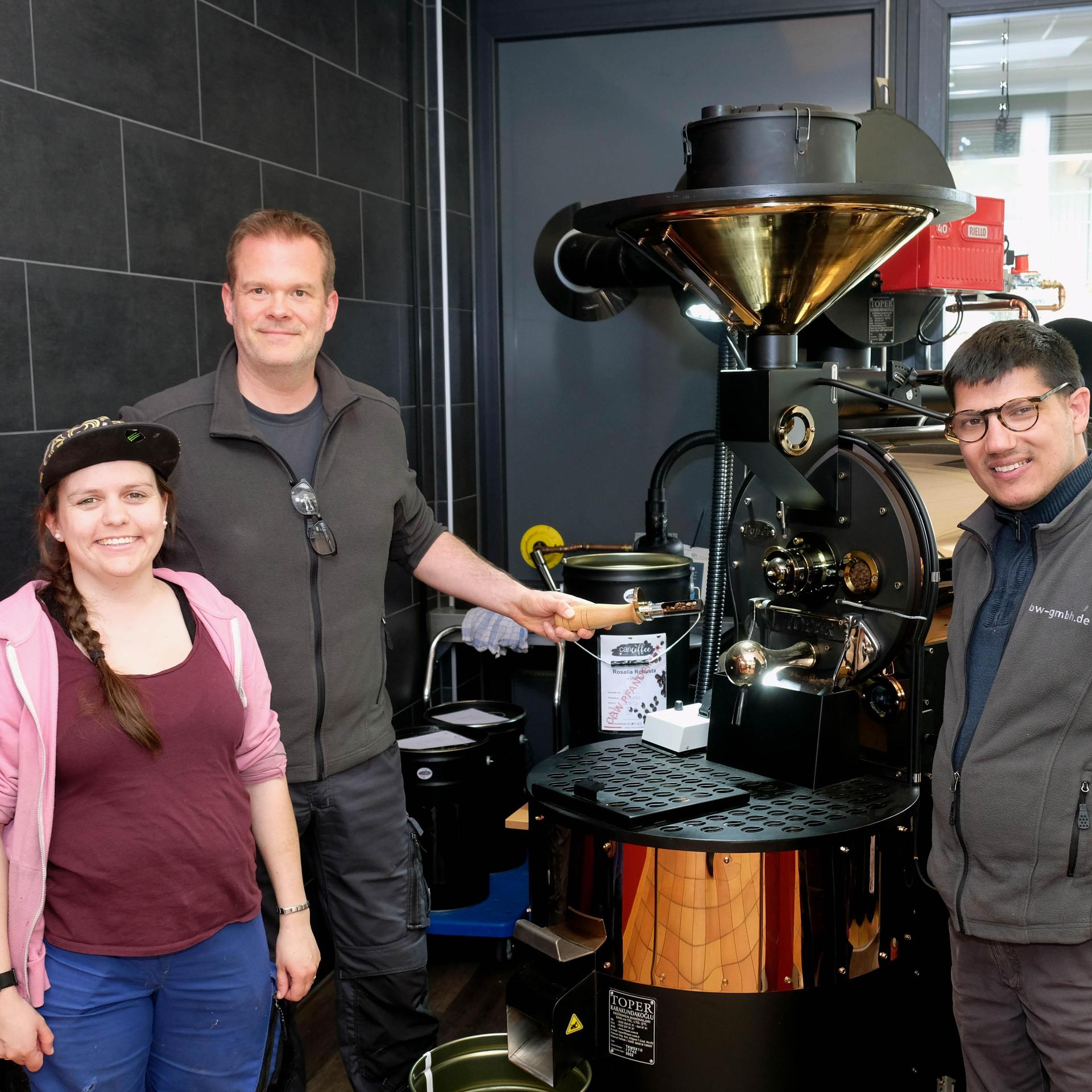 Der Kaffee ist bald fertig: Tobias Fink ist bei der Caritas-Werkstatt Imgenbroich zuständig fürs Kaffeerösten. Mara Offermann und Jannick Mohr (re.), die beide in der Werkstatt beschäftigt sind, unterstützen den Vorgang.
