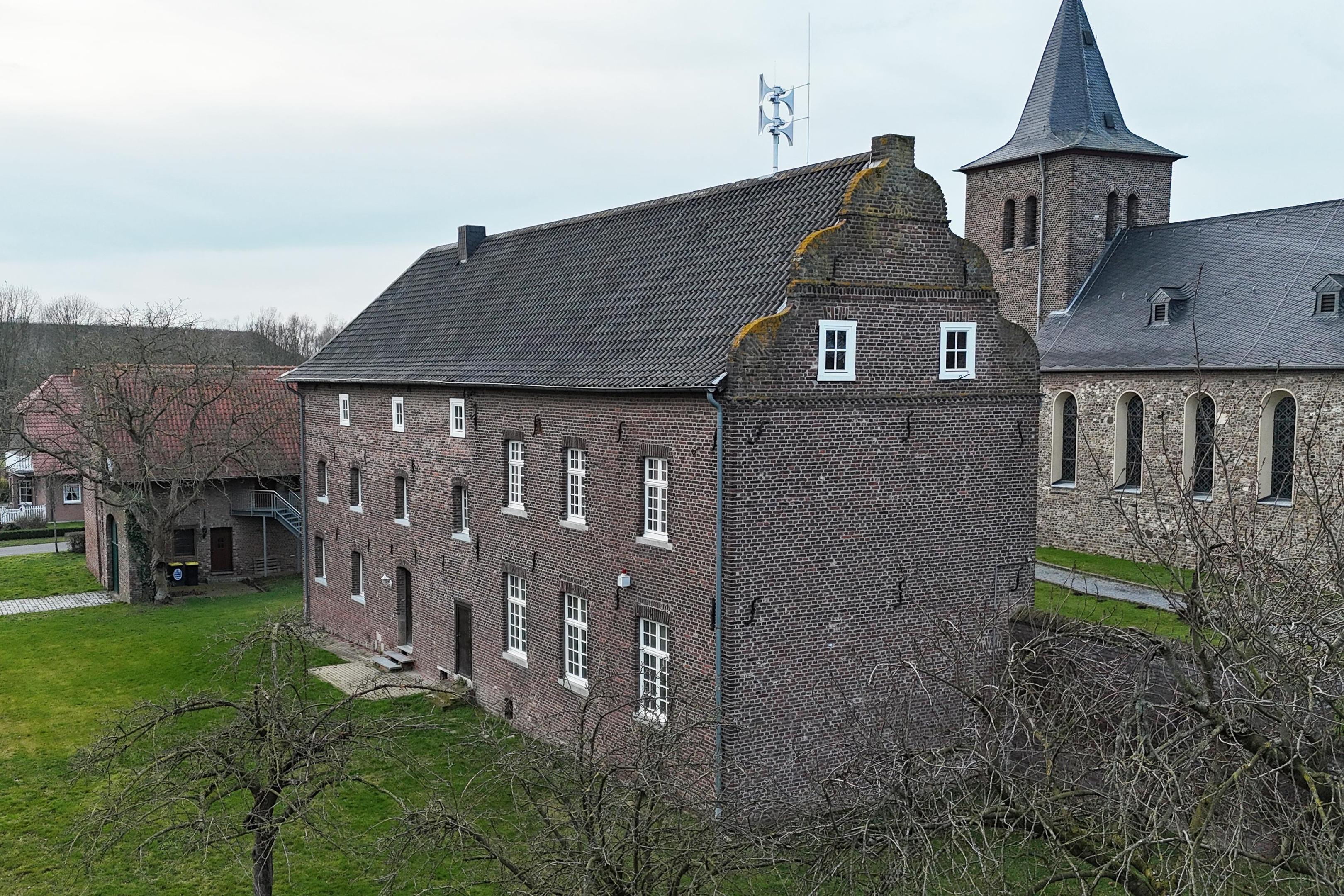 Zwei steinerne Zeitzeugen auf einem Bild: Erich Hacken hat seine Drohne aufsteigen lassen und Propstei und Kirche St. Nikolaus in Millen von oben eingefangen.