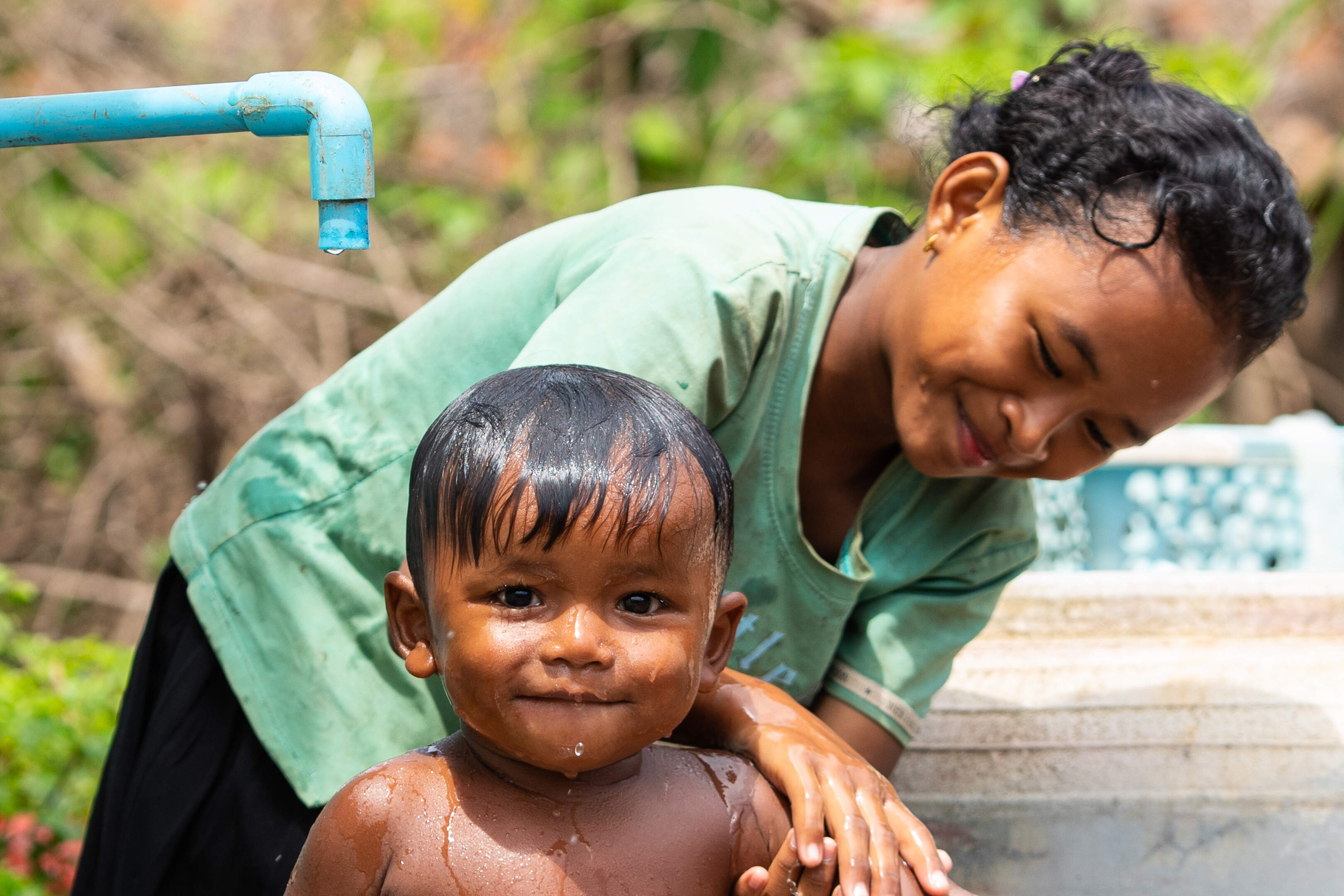 Die zehnjährige Nang Sok badet ihren kleinen Bruder Sak Ponleu. 