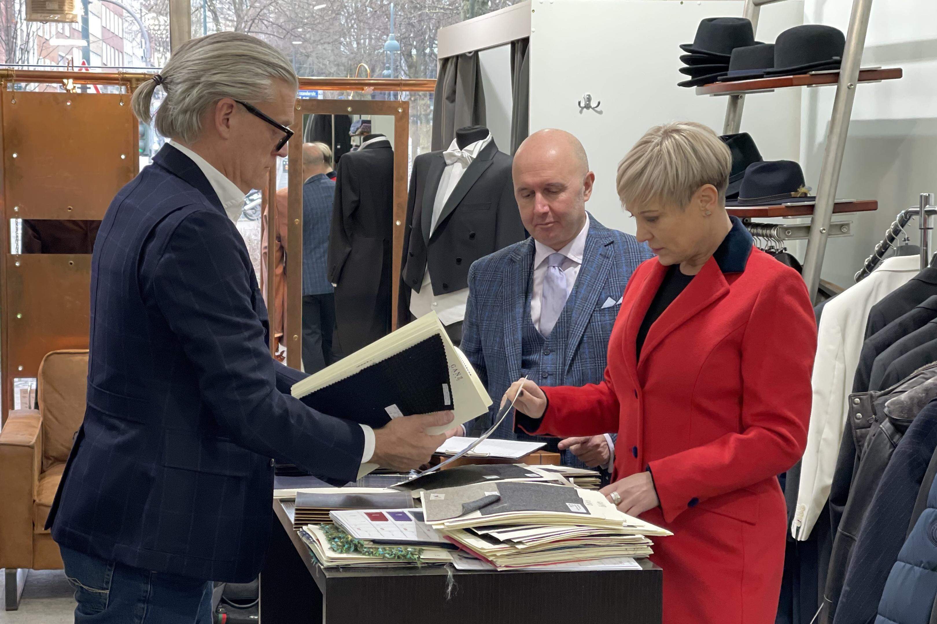 Hier wird gerade kräftig beim Modeproduzenten geordert: Frank und Michaela Wienand beraten sich mit Paolo Ganz (M.) an einer Bedientheke in ihrem Geschäft in der Alexanderstraße. 