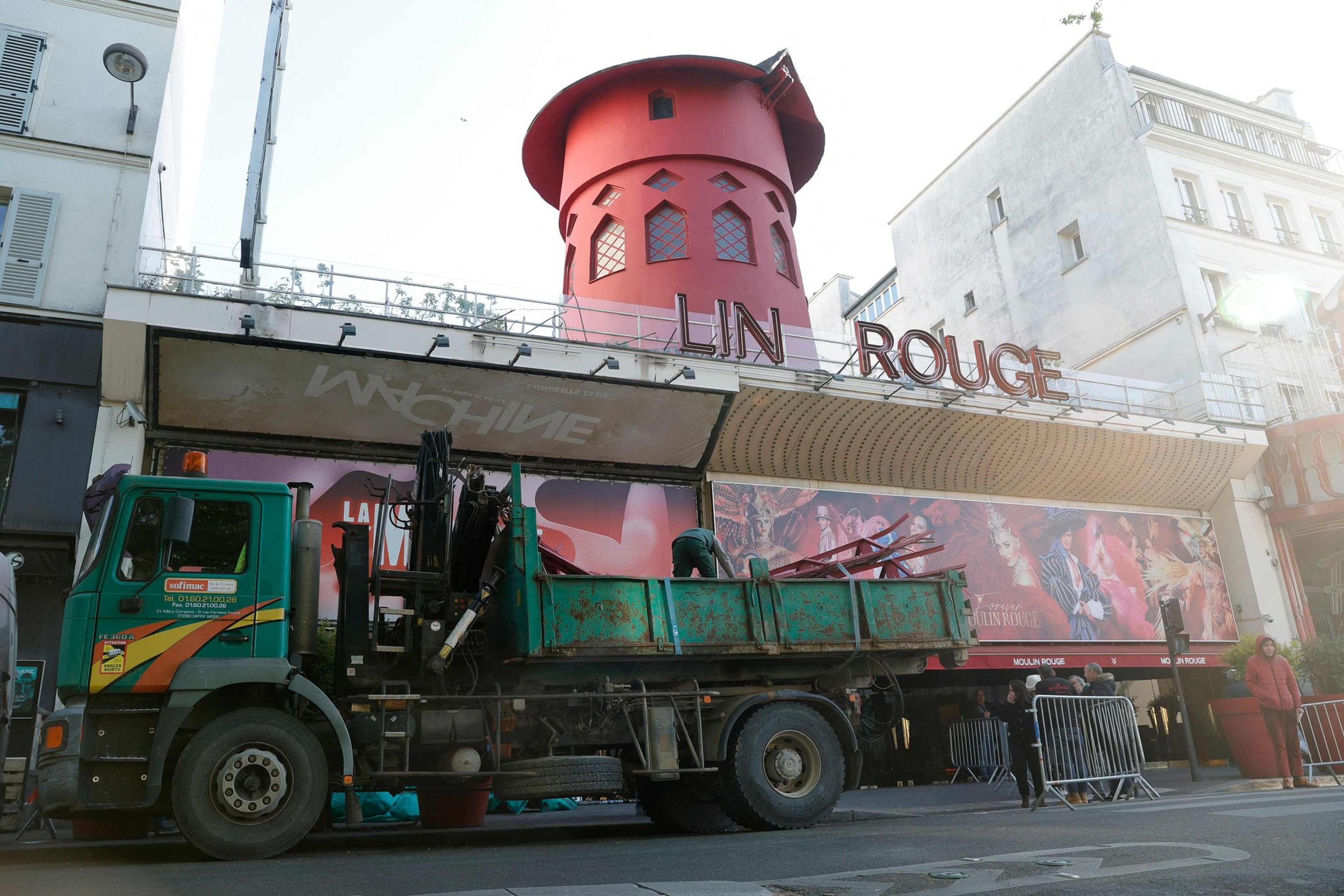 Arbeiter sichern den Bereich vor dem Kabarett, nachdem die Flügel des Windrads des „Moulin Rouge“ in der Nacht abgestürzt sind.