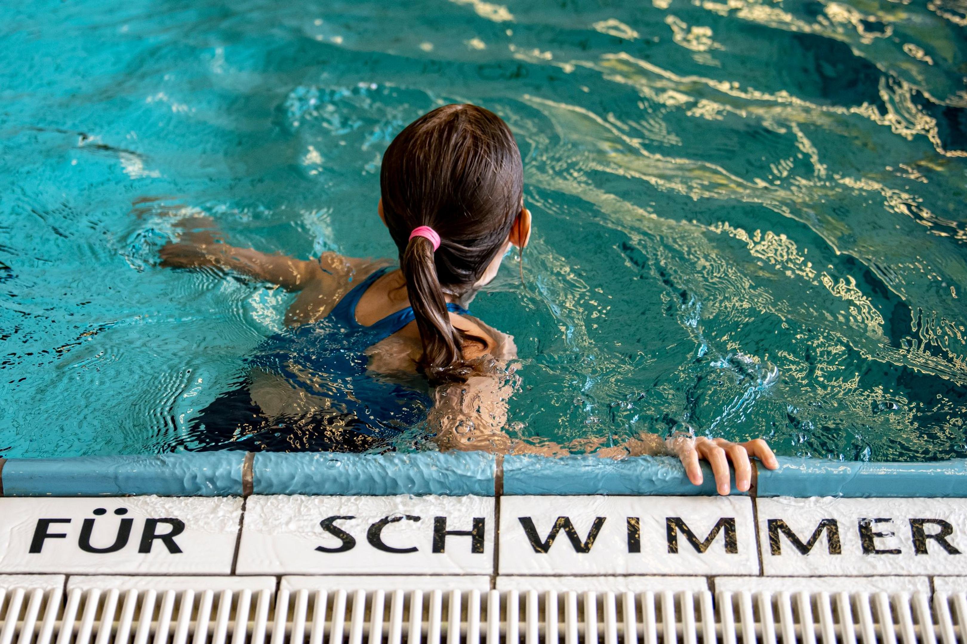 Ein Kind schwimmt in einem Schwimmbad.