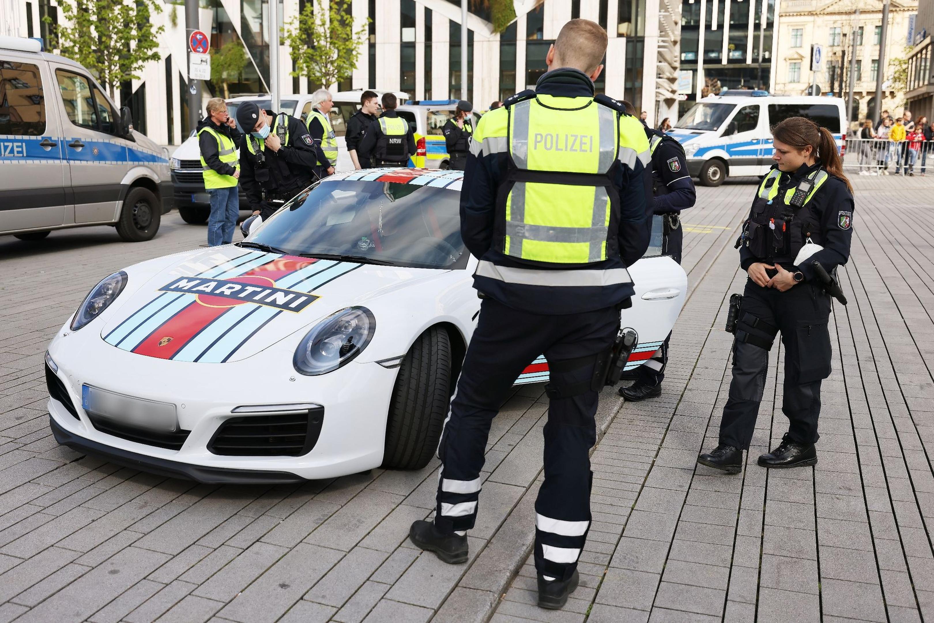 Polizeibeamte kontrollieren einen Porsche beim Tuner- und Poser-Treffen am „Car-Freitag“.